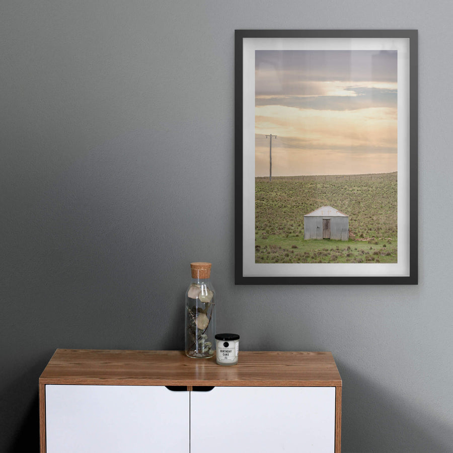 Springfield Drovers Hut at A Place to Call Home, a single corrugated iron hut sits low in open grassland.