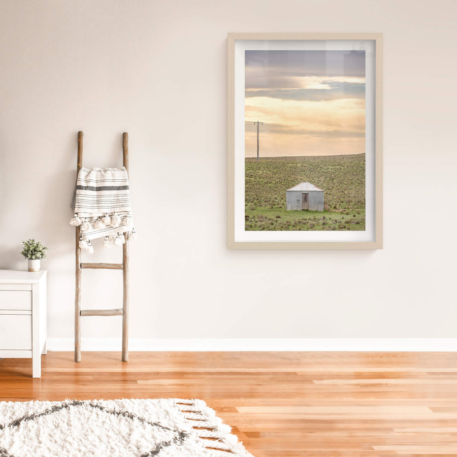 Springfield Drovers Hut at A Place to Call Home, a single corrugated iron hut sits low in open grassland.
