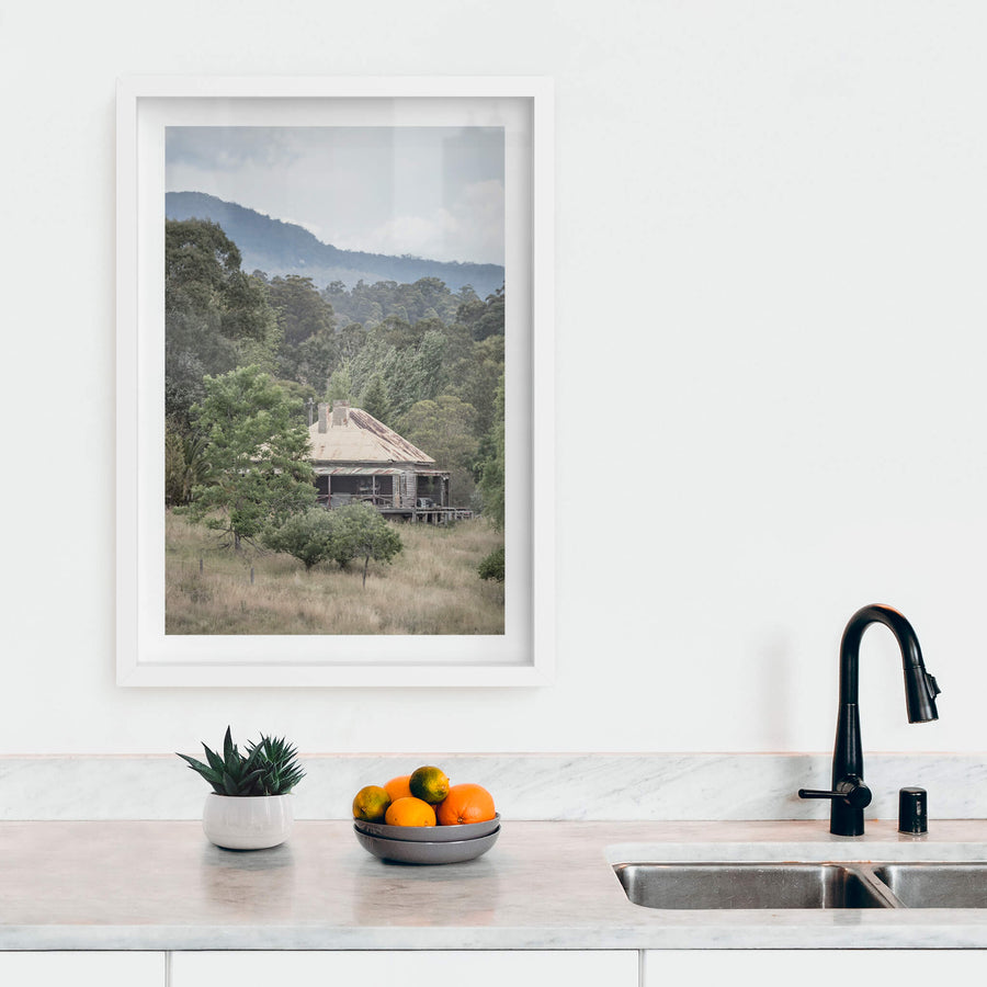 Wyndam Home at A Place to Call Home, a weatherboard homestead sits low in dry grass, its hipped roof a patchwork of rust.