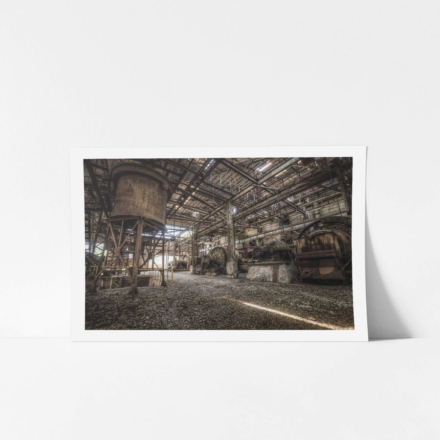 Ball Mills at Ashio Copper Mine, a cylindrical hopper rises on steel legs to the left, rust coating every surface in deep.