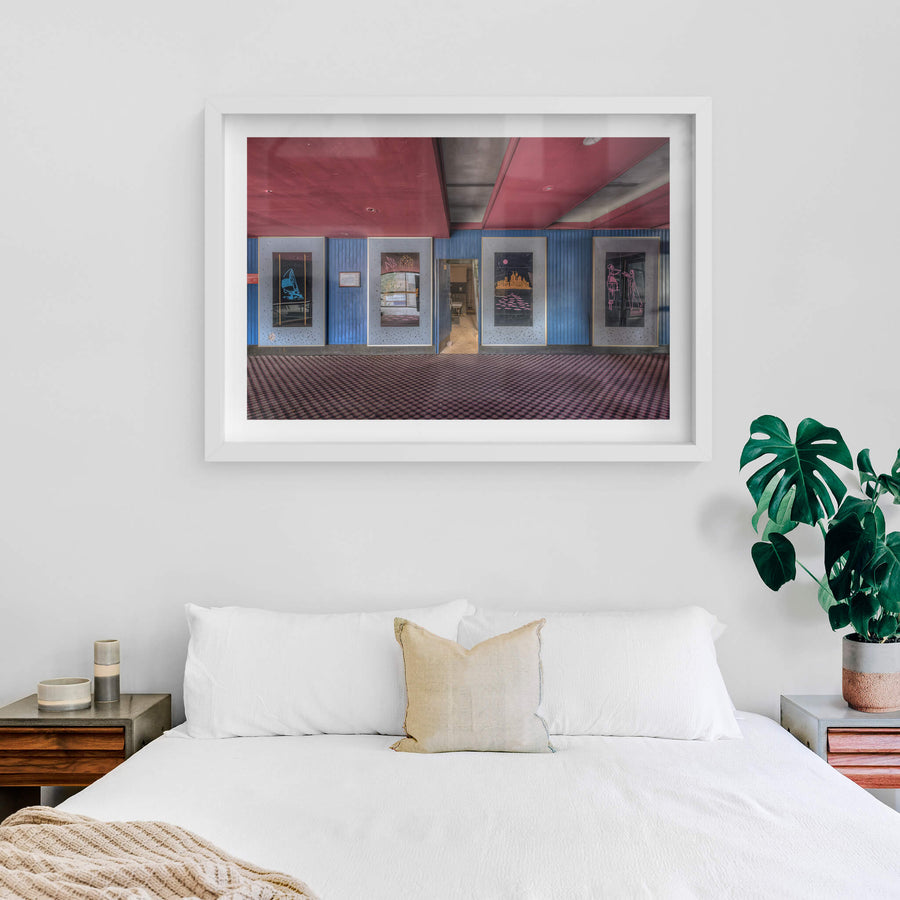 Foyer Art at Bankstown RSL, five framed artworks line the foyer wall, mounted on blue timber panelling punctuated.