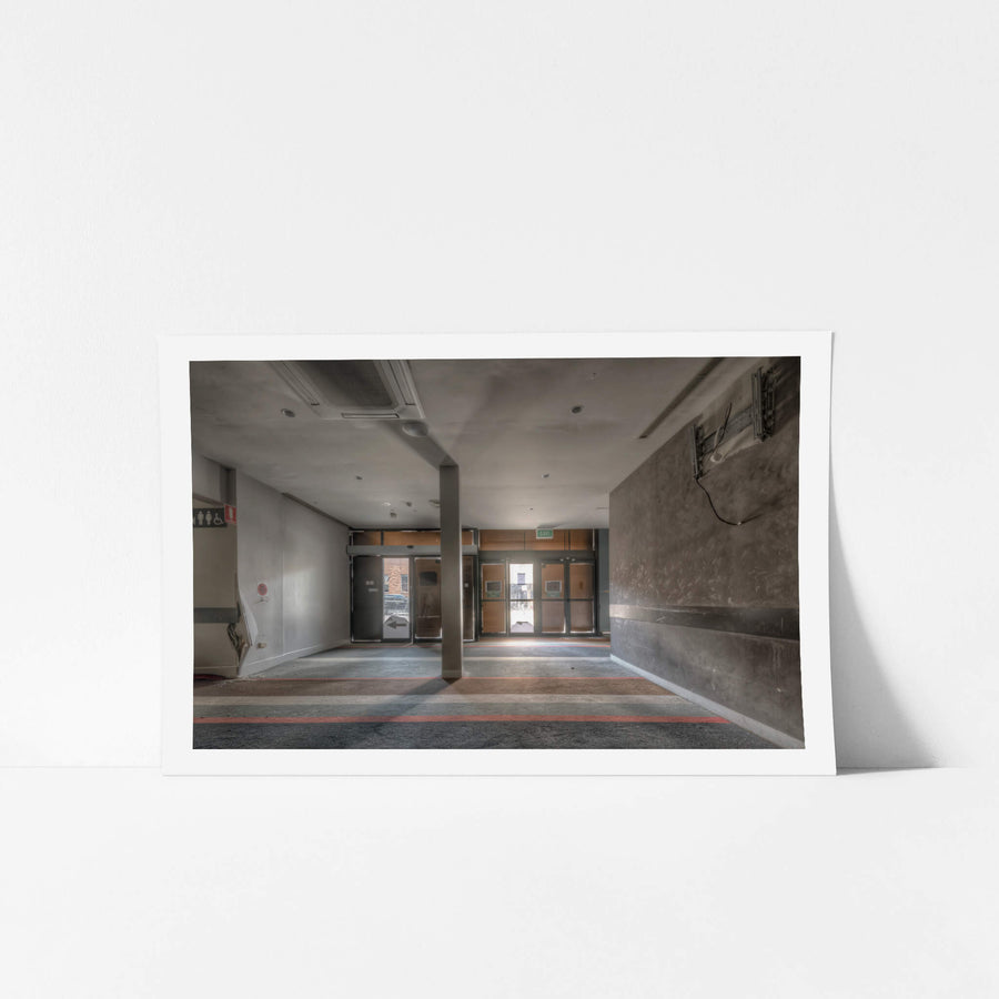 RSL Entrance at Bankstown RSL, a concrete column stands centre-frame, splitting the foyer into two grey corridors.