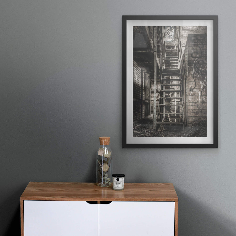 Stairs To Level Two at Bathurst Gasworks, a steel staircase climbs between brick walls, bolted to a narrow column.