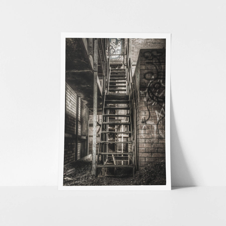 Stairs To Level Two at Bathurst Gasworks, a steel staircase climbs between brick walls, bolted to a narrow column.