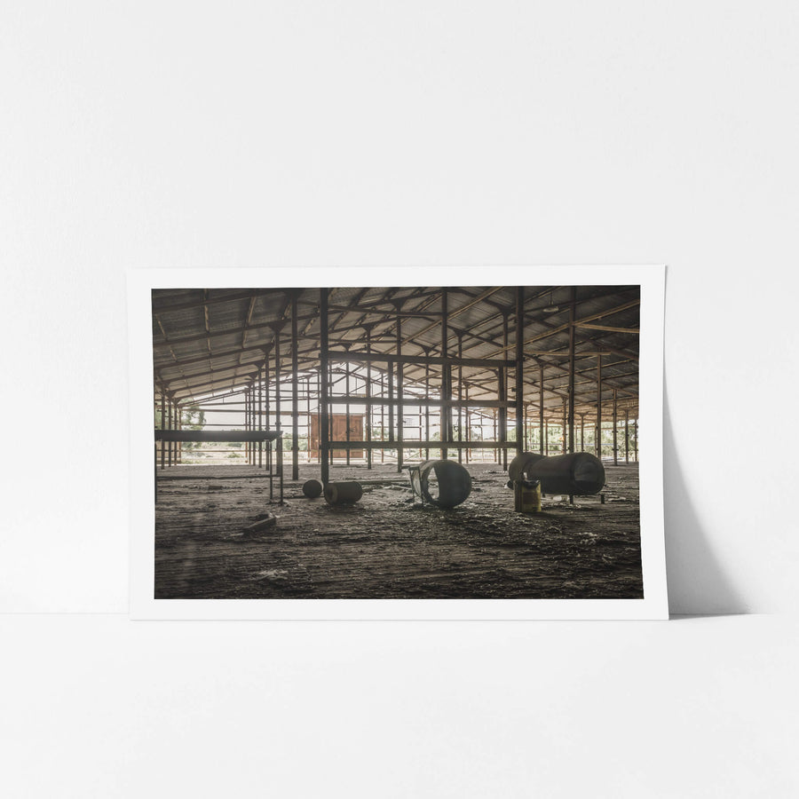 Top Holding Area at Blayney Abattoir, steel columns support a wide corrugated roof over a dirt floor thick with dried mud.