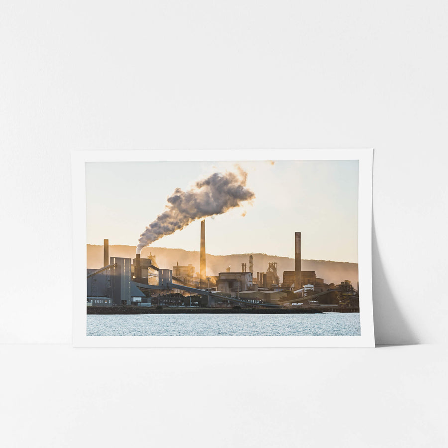 Port Kembla Sunset at BlueScope Port Kembla, smoke pours from a tall stack and drifts south across the steelworks skyline.