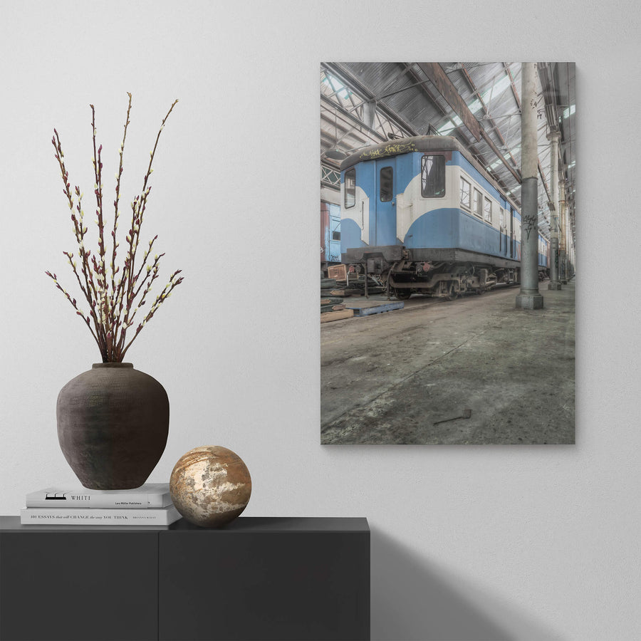 Phillip Shirley at Eveleigh Paint Shop, a blue and white railway carriage sits on bare concrete inside the Eveleigh Paint Shop.