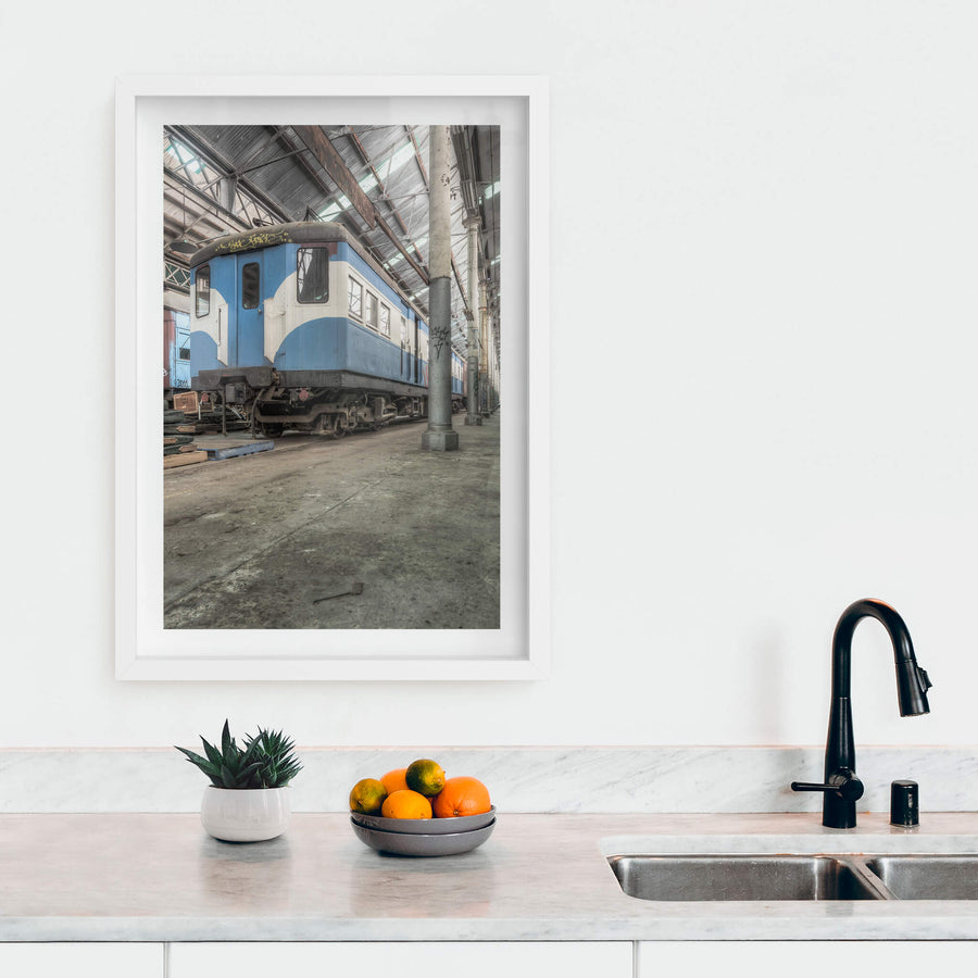 Phillip Shirley at Eveleigh Paint Shop, a blue and white railway carriage sits on bare concrete inside the Eveleigh Paint Shop.