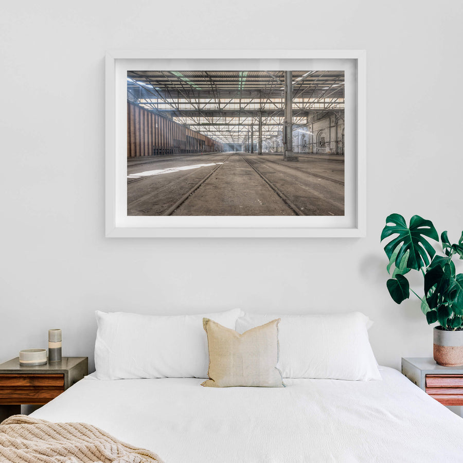 Suburban Car Workshop Facing East at Eveleigh Paint Shop, light spills through the sawtooth roof, filtering through layers of steel and glass to cast long shadows across the dust-laden floor.