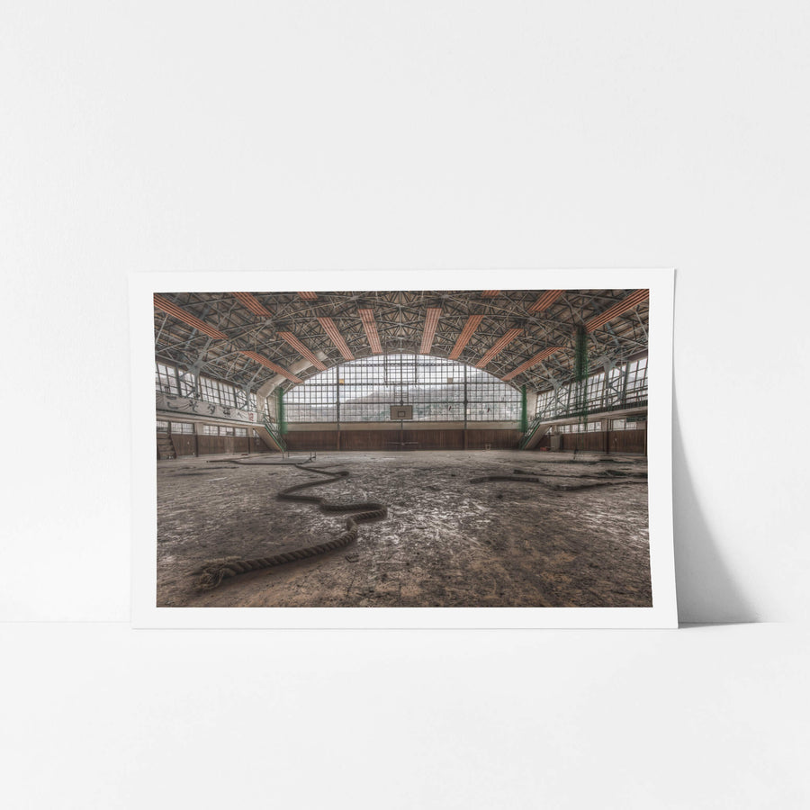 Gymnasium at Family School Fureai, a thick climbing rope lies coiled across the gymnasium floor like something shed.