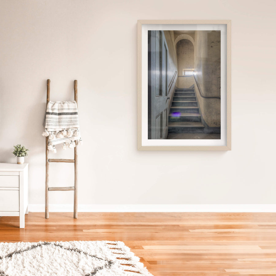 Flare at Female Ward 9 & 10, a narrow stairwell climbs between plaster walls stained grey and ochre with damp.