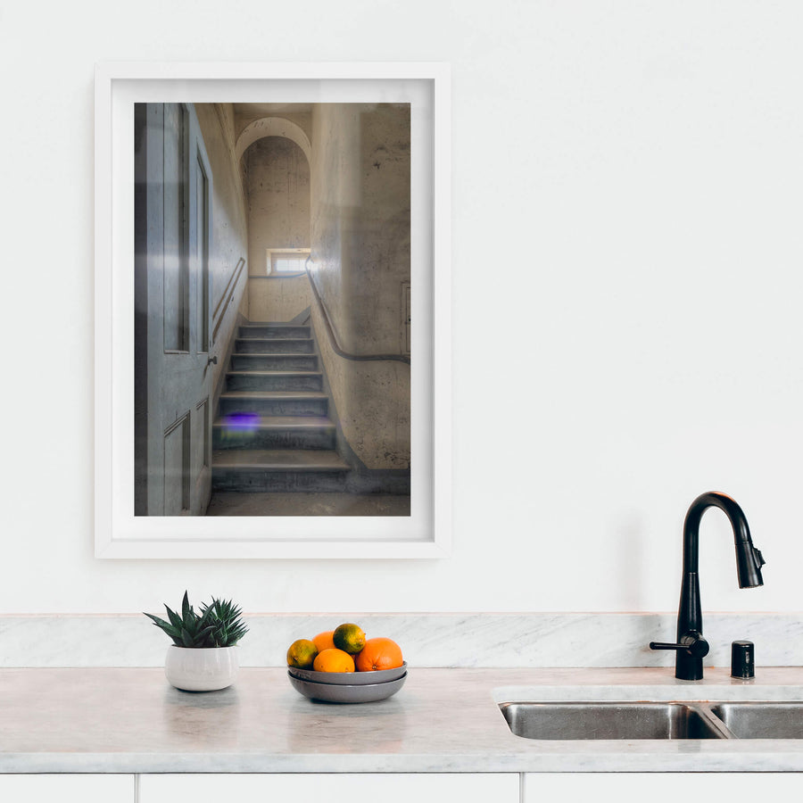 Flare at Female Ward 9 & 10, a narrow stairwell climbs between plaster walls stained grey and ochre with damp.