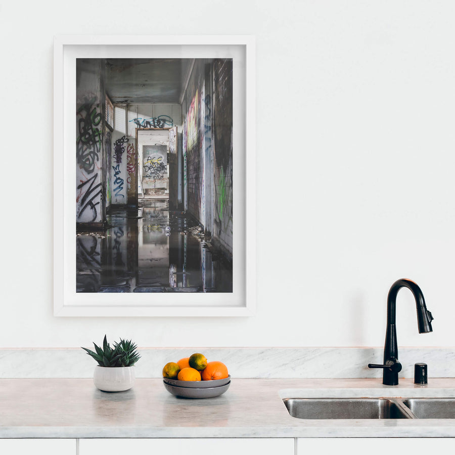 Reflections at Geelong B Power Station, standing water covers the corridor floor, black and still enough to mirror.