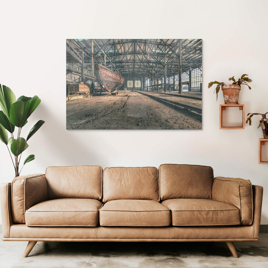 Checkerplate at Halvorsens Boat Yard, a timber hull sits propped on blocks inside a vast industrial shed.