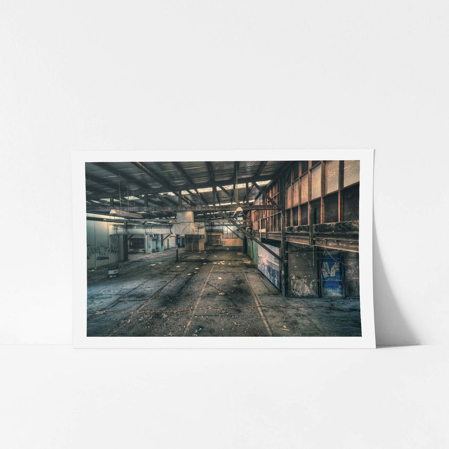 Mezzanine at Halvorsens Boat Yard, steel trusses span the full width of the shed, bolted to rust-streaked columns.