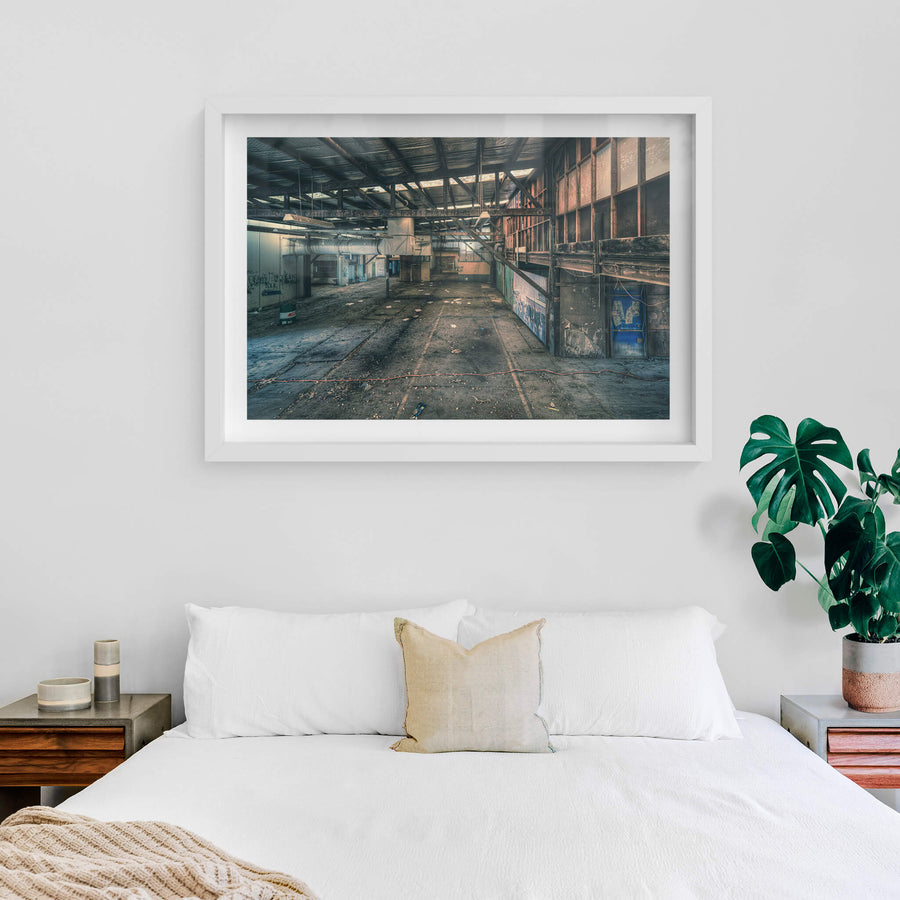 Mezzanine at Halvorsens Boat Yard, steel trusses span the full width of the shed, bolted to rust-streaked columns.