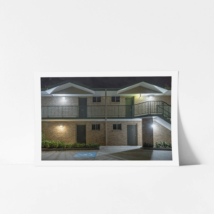 Chittaway Motel at Hotel Motel 101, two storeys of cream brick face the empty car park.