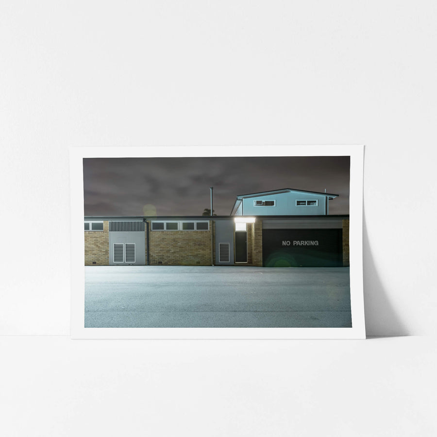 Twin Willows at Hotel Motel 101, a single floodlight burns above a narrow doorway, throwing cold white light.