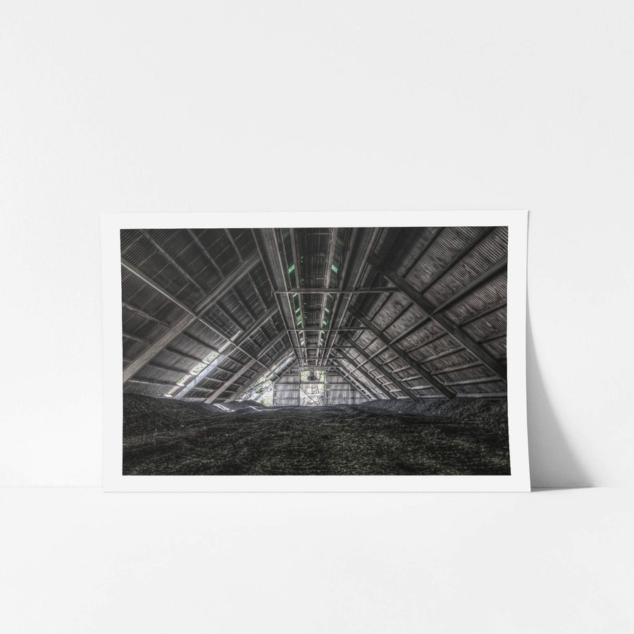 Raw Stone Shed at Kandos Cement Works, dark heaps of crusite and stone dust cover the floor, rising in uneven mounds.