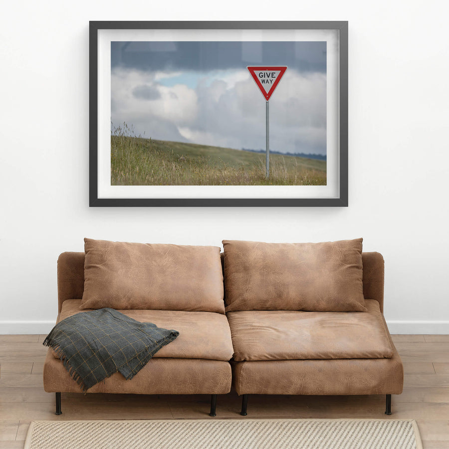 Give Way at Landscapes, a galvanised steel post rises from long grass on a bare hillside.