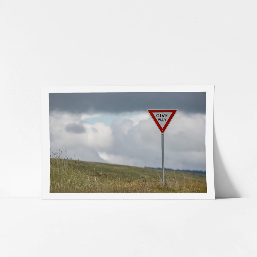 Give Way at Landscapes, a galvanised steel post rises from long grass on a bare hillside.