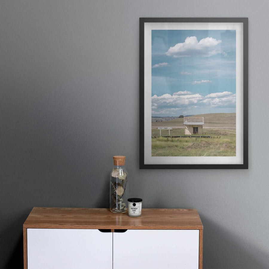 Jincumbilly Station at Landscapes, a single cream-painted shelter sits on a low timber platform surrounded by open grassland.