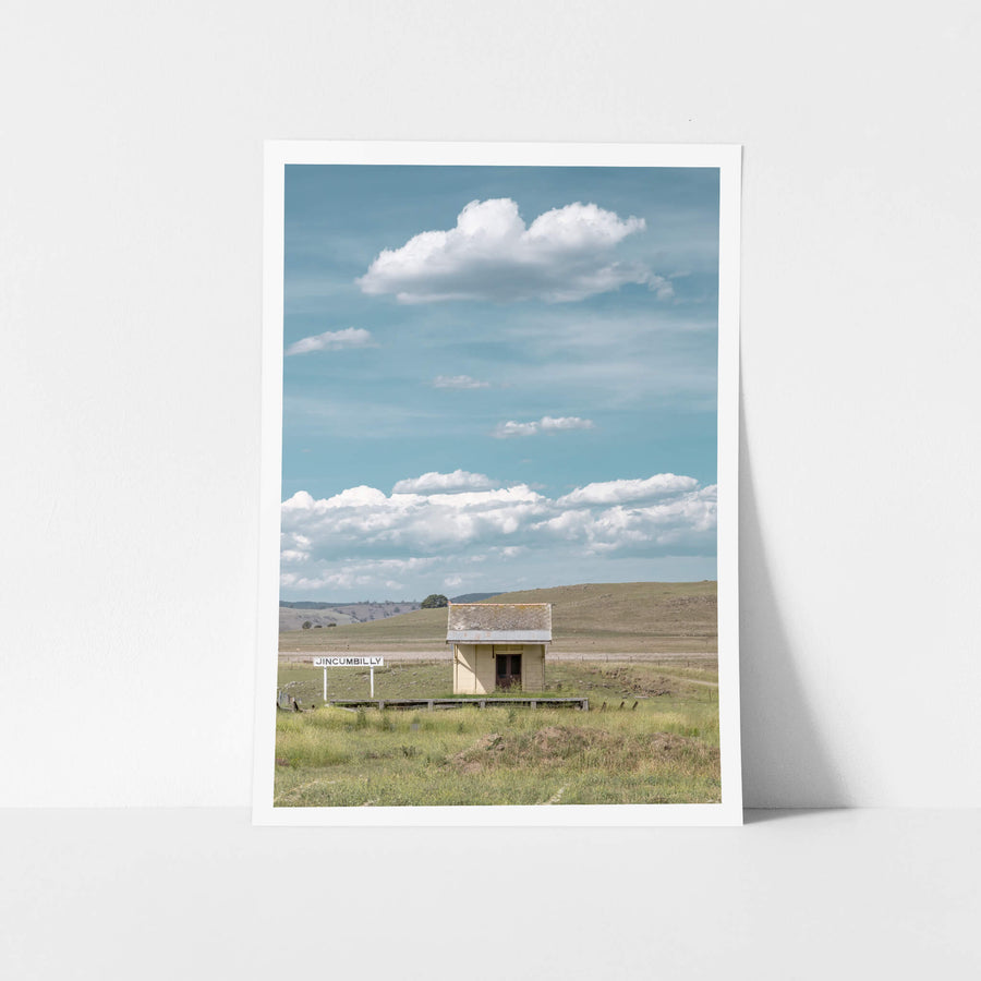 Jincumbilly Station at Landscapes, a single cream-painted shelter sits on a low timber platform surrounded by open grassland.
