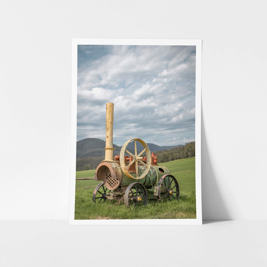 Steam Machine at Landscapes, a portable steam engine sits in open pasture, its iron wheels sunk into thick green grass.