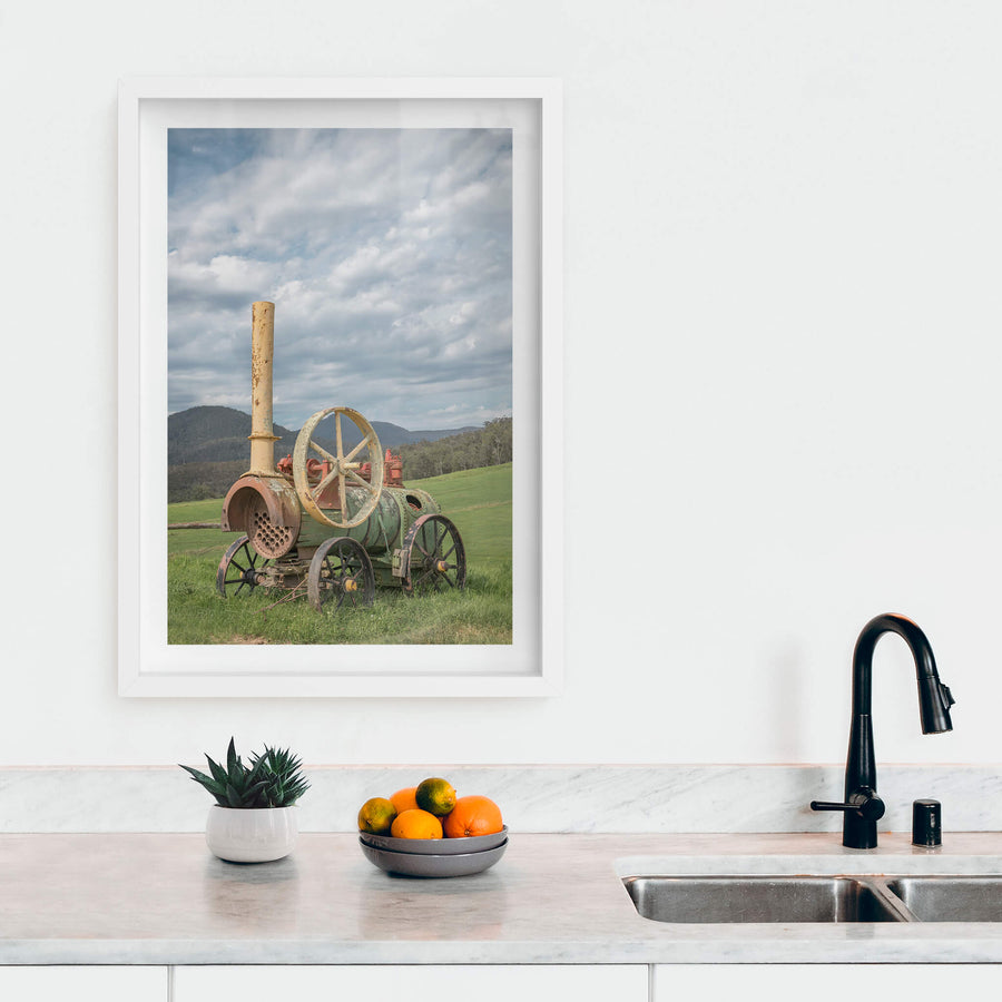 Steam Machine at Landscapes, a portable steam engine sits in open pasture, its iron wheels sunk into thick green grass.