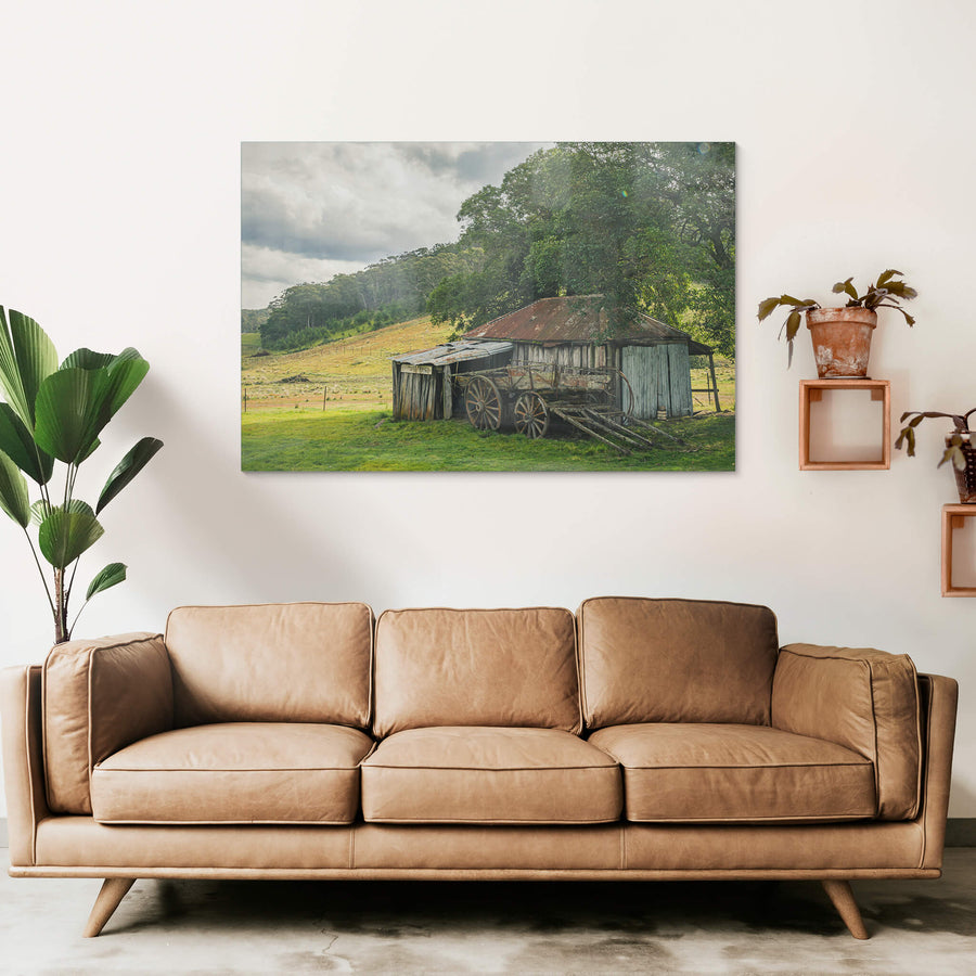 Hills at Leichhardt House, a weathered timber shed sits low against green pasture, its corrugated iron roof streaked deep.
