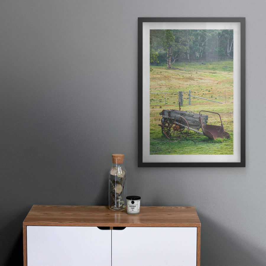 Wagon at Leichhardt House, a horse-drawn wagon sits on green grass beside a wire fence line.