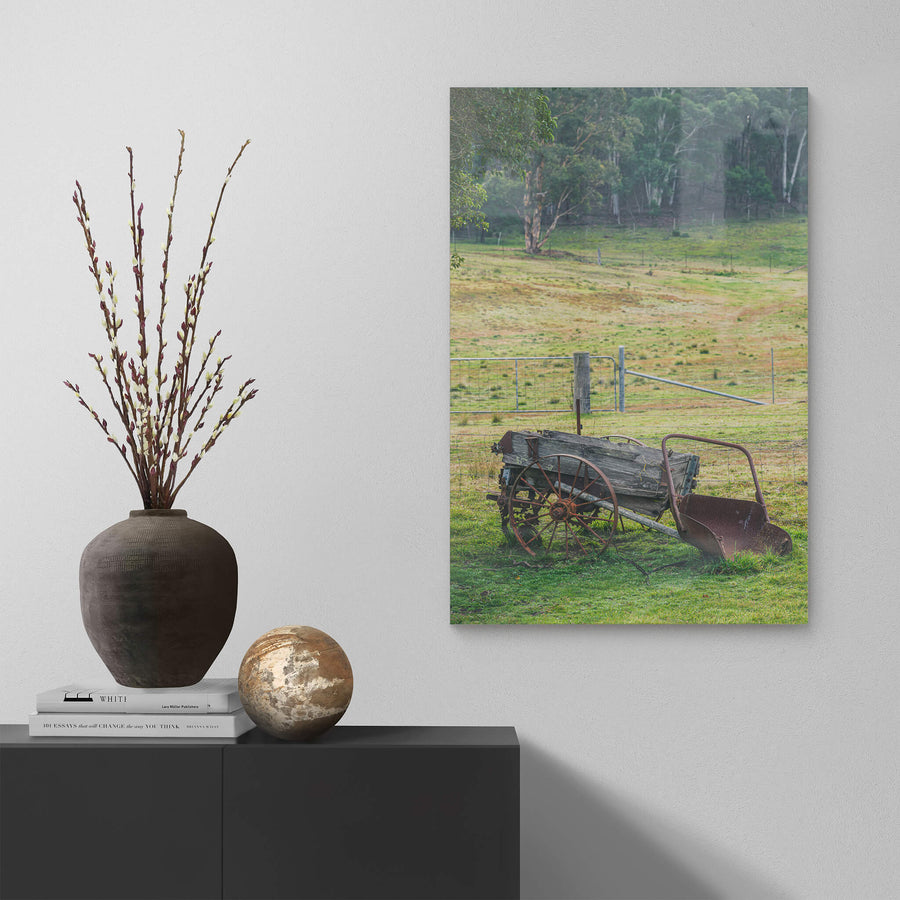 Wagon at Leichhardt House, a horse-drawn wagon sits on green grass beside a wire fence line.