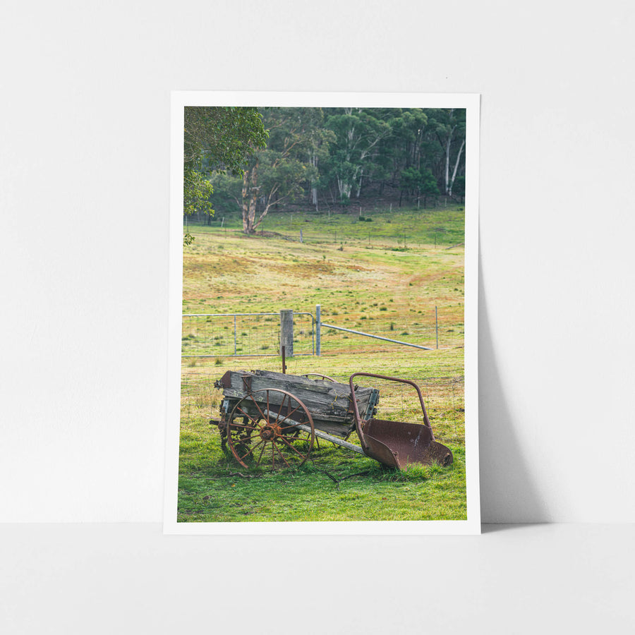 Wagon at Leichhardt House, a horse-drawn wagon sits on green grass beside a wire fence line.
