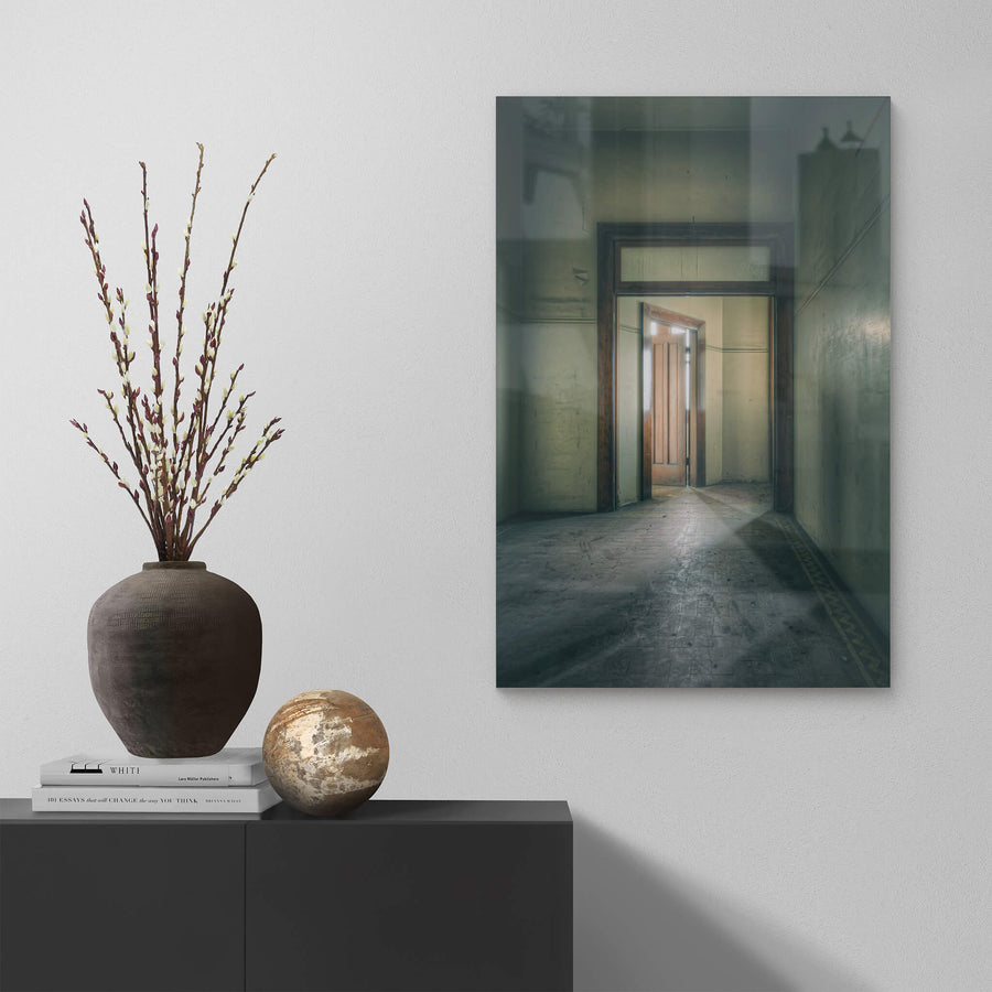 Enclave at Lewisham Hospital, a narrow corridor leads to a timber door, half-open, light pressing through the gap.