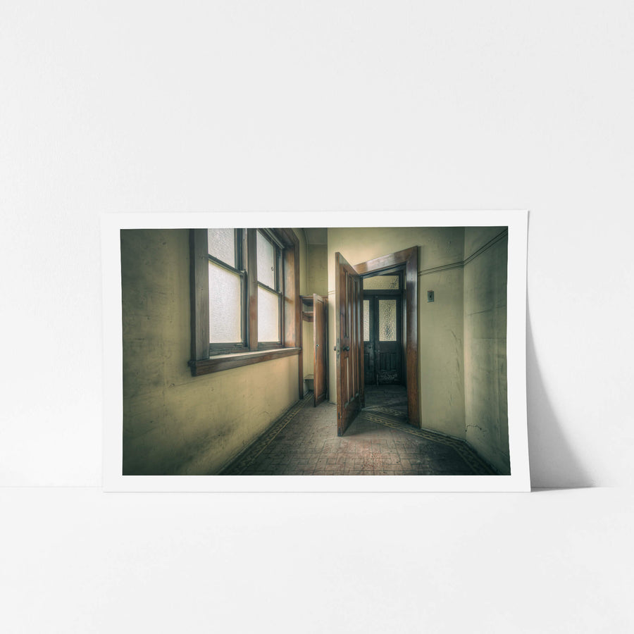 Storage at Lewisham Hospital, a narrow corridor leads to an open timber door.