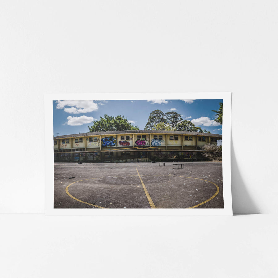 Basketball Court Panorama at Macquarie Boys Technology High, a two-storey classroom block curves around an empty basketball.
