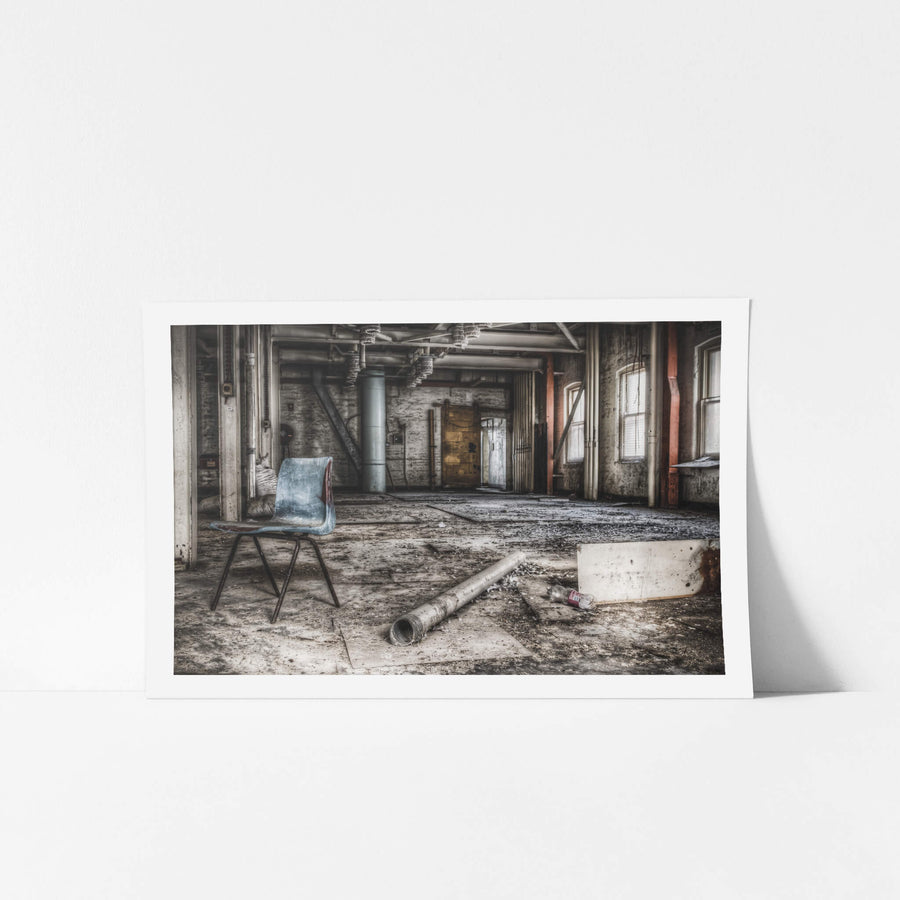 Bagging Room at Mungo Scott Flour Mill, a blue moulded-plastic chair sits alone on a concrete floor thick with grit and dust.