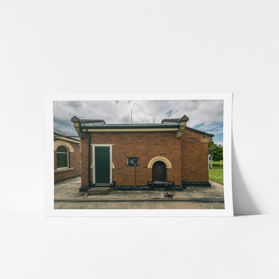 Issue Hatch at Newington Armory, a squat red-brick building sits square against a concrete apron.