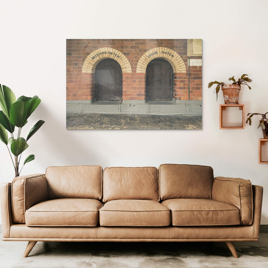 Recieving Issue at Newington Armory, two arched hatches sit side by side in a red brick wall.