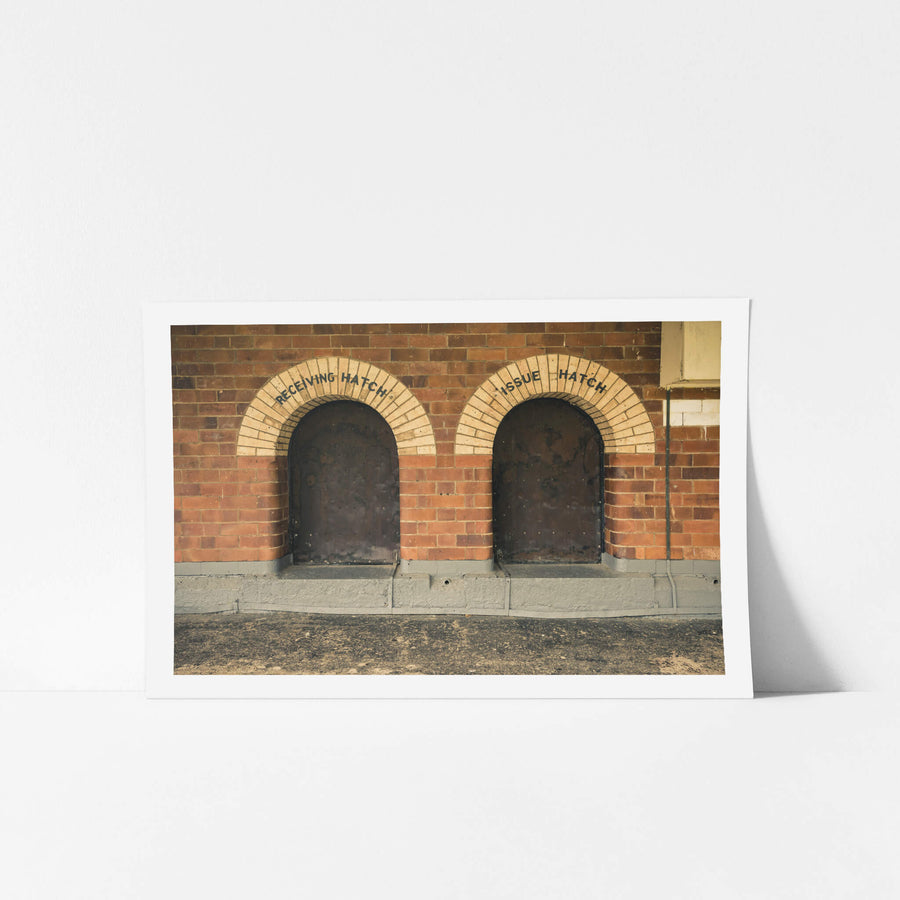 Recieving Issue at Newington Armory, two arched hatches sit side by side in a red brick wall.