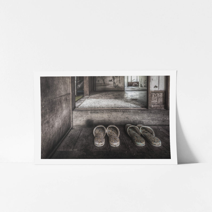 Genkan at Nichitsu Mining Village, two pairs of slippers sit on the worn timber floor of a genkan, their floral fabric.