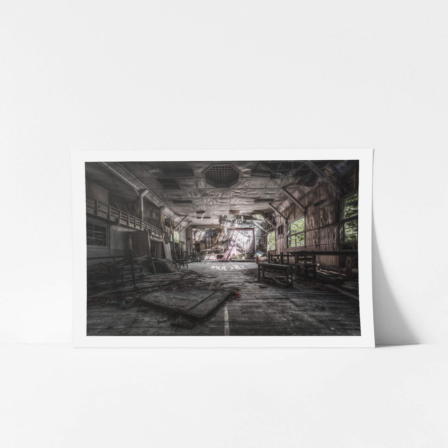 Theatre at Nichitsu Mining Village, a collapsed stage curtain hangs in shreds at the far end of the hall.