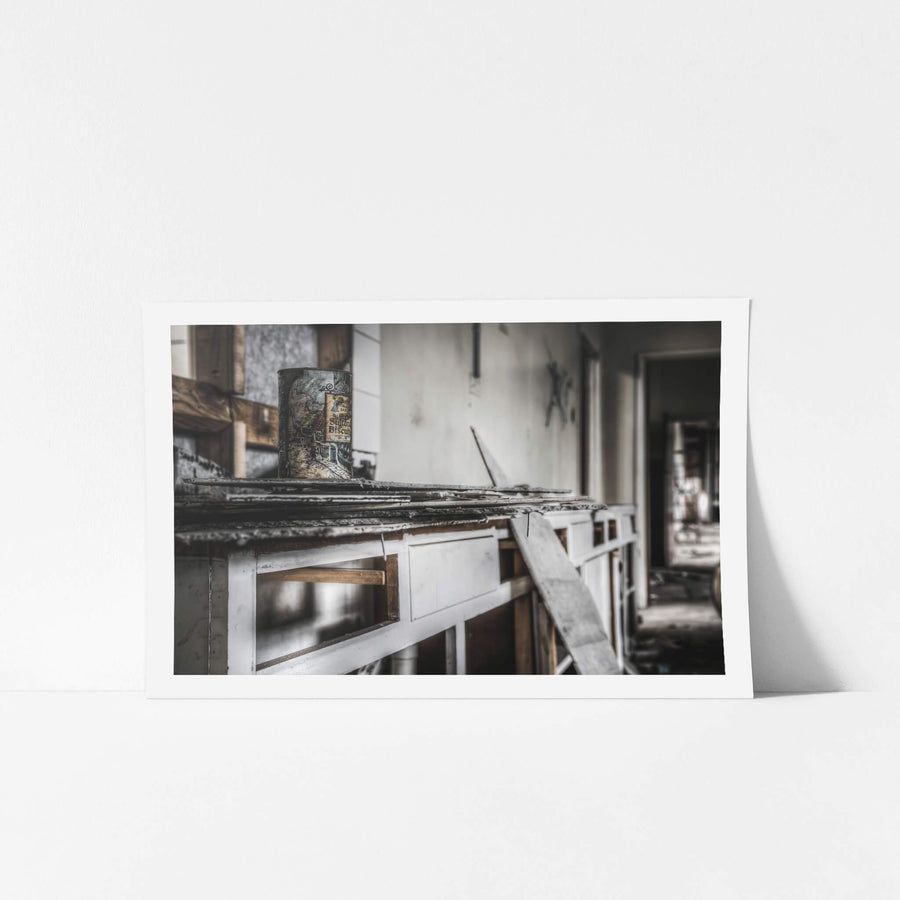 Dining Room at O-I Glass, a sultana biscuit tin sits on the counter of a stripped kitchen.