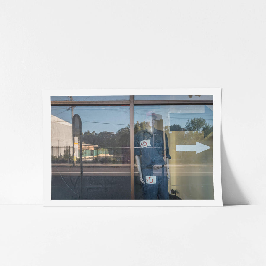 10 Dollar Look at Parramatta Road, a mannequin stands behind plate glass in a closed shopfront on Parramatta Road.