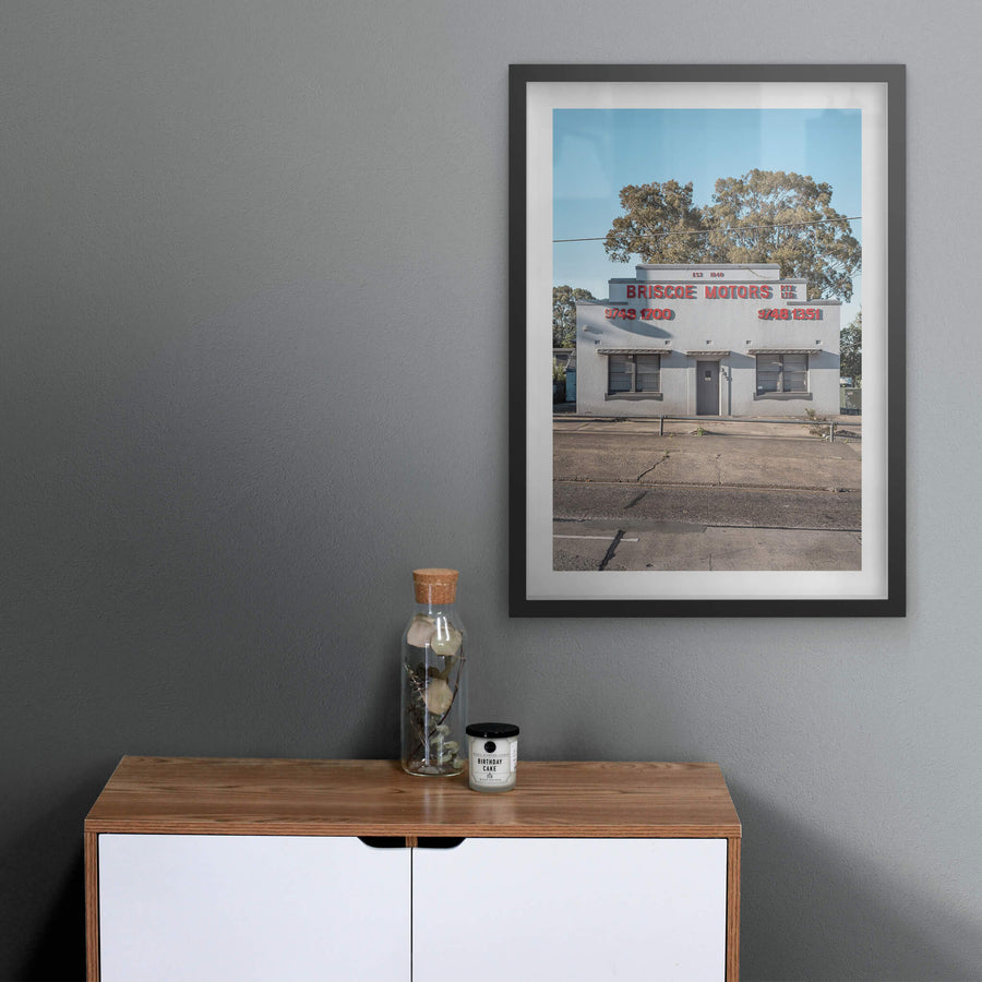 Briscoe Motors at Parramatta Road, a white rendered Art Deco façade sits square to the street.