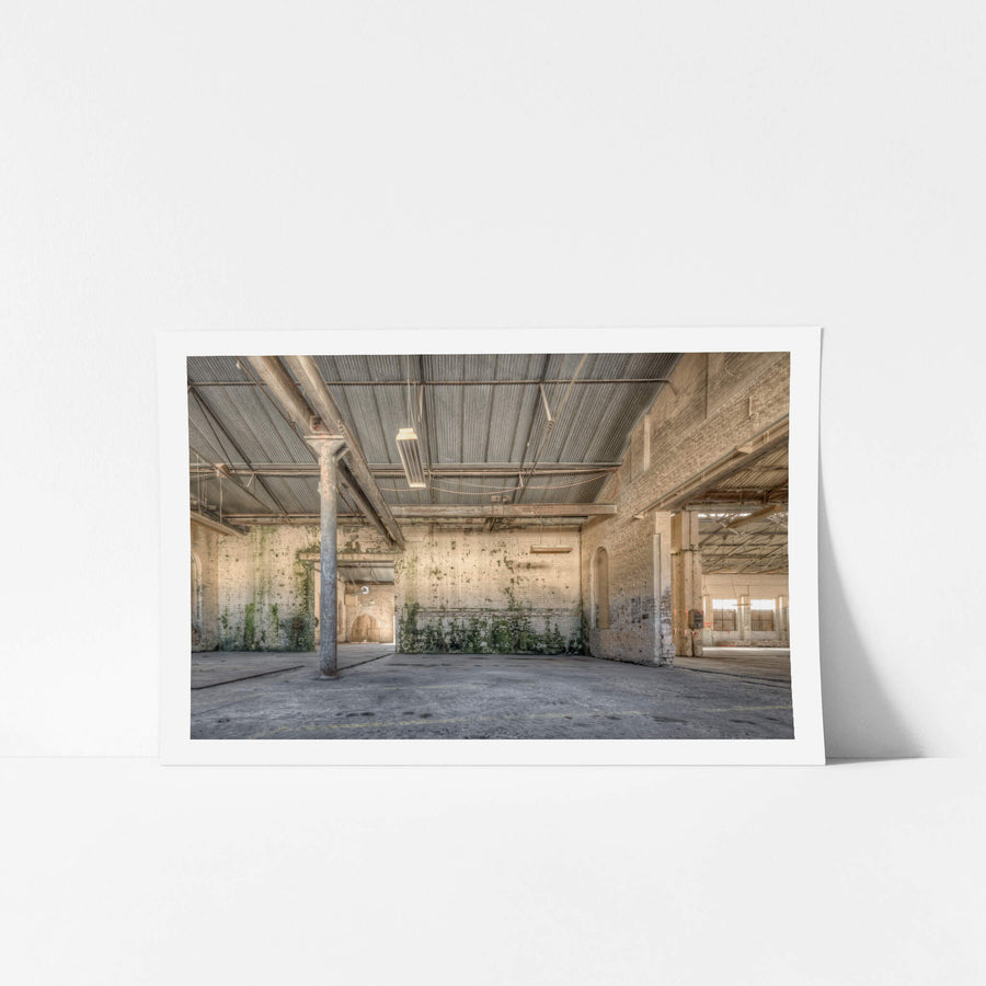 Blacksmith Workshop at Portland Cement Works, a steel column rises from the concrete floor to a corrugated iron roof.