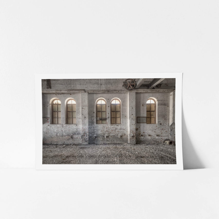 Boarded Arches at Portland Cement Works, three arched windows line the interior brick wall, their lower panes boarded.