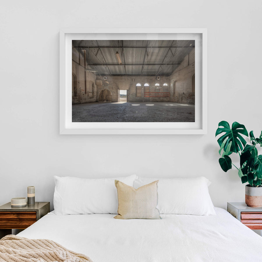 Opening at Portland Cement Works, pale brick walls rise to a corrugated iron roof inside one of the Portland Cement Works.