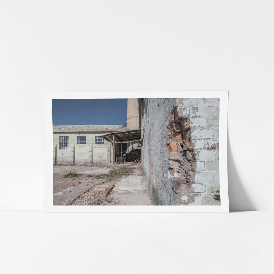 Power House Corner at Portland Cement Works, pale green paint peels from blockwork walls where the render has fallen away.