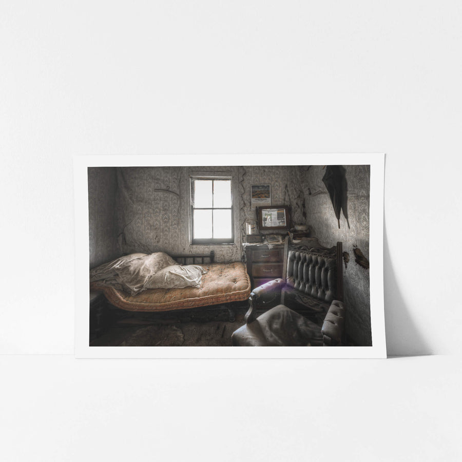 Side Bedroom Window at Woolla, a single iron-frame bed sits against the far wall, its faded orange mattress still bearing.